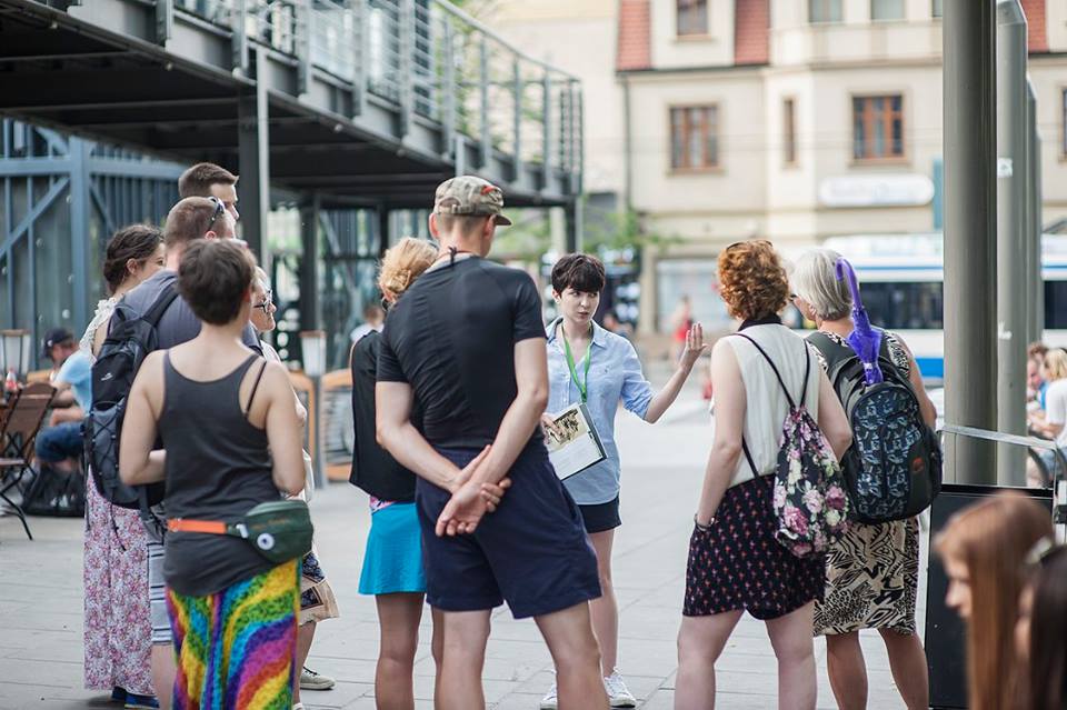 Kilka osób stojących w przestrzeni publcznej, na ulicy
