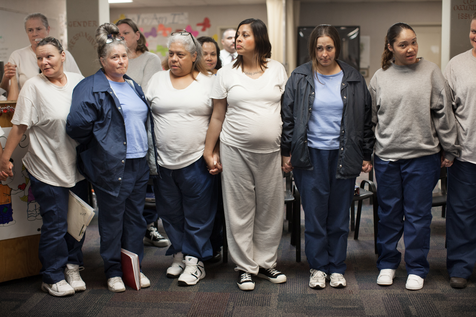 Zdjęcie 5 kobiet uwiezionych w areszcie, które doatkowo są w ciąży. Połowa z nich ubrana jest na granatowo, druga na beżowo.