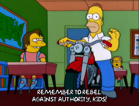 Obrazek z bajki Simsonowie. Ojciec na motorze siedzi w szkolnej klasie i nawołuje dzieci do rebelianctwa.