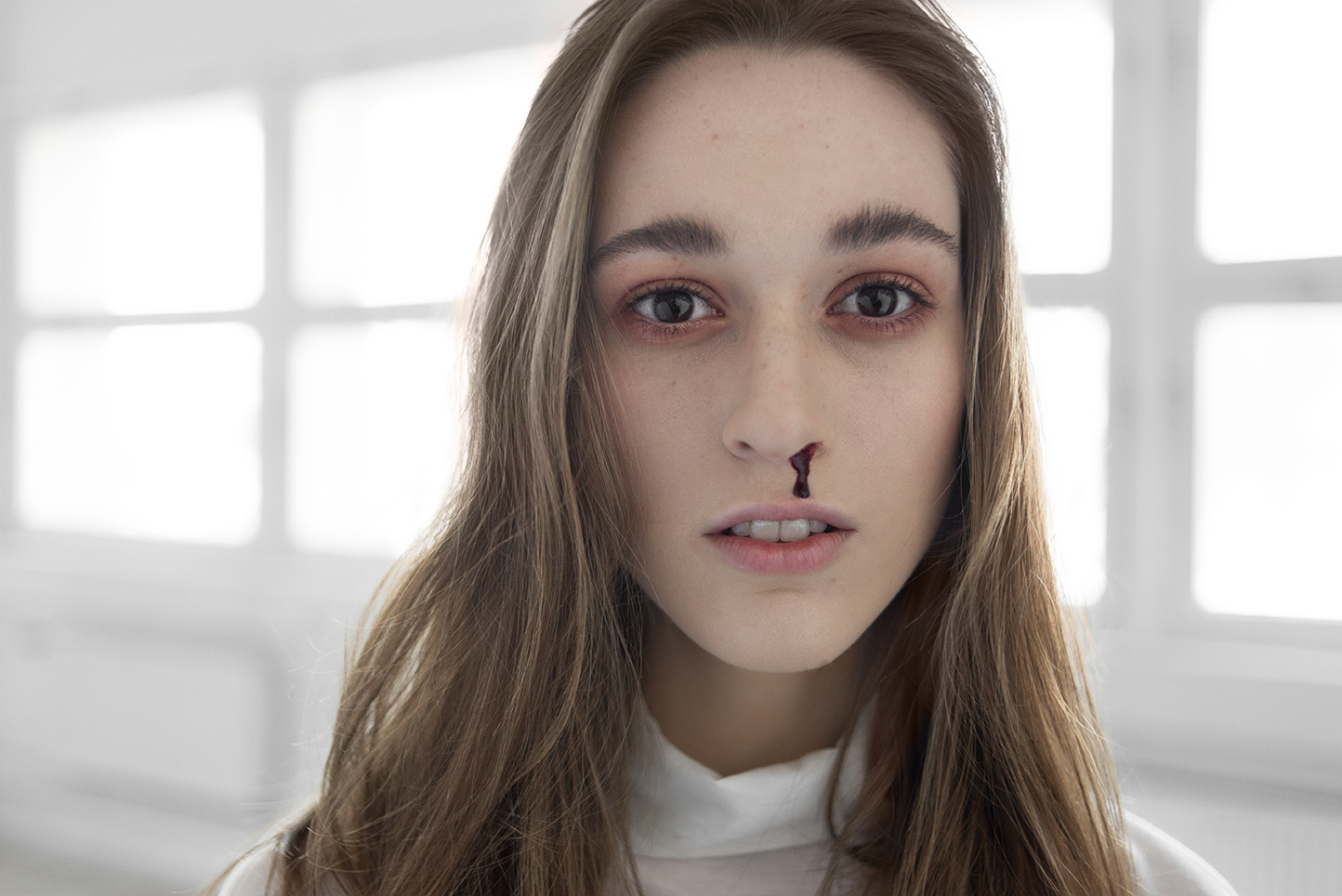 Portret dziewczyny z podkrążonymi oczami i krwią z nosa