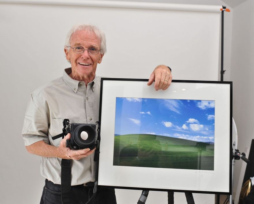 Starszy mężczyzna stojący ze zdjęciem łąki
