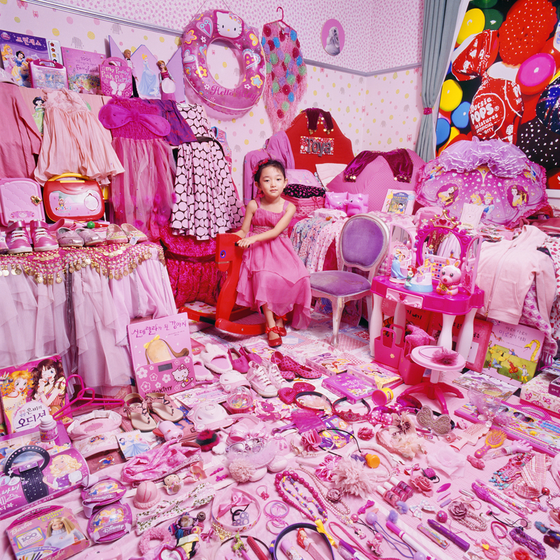 Dziewczyna siedząca wśród różowych zabawek
