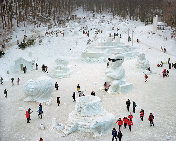 Zimowy park rozrywki z rzeźbami ze śniegu i ludzie dookoła