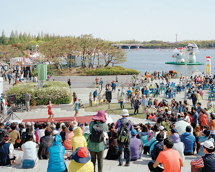 Ludzie zgromadzeni nad rzeką, oglądający pokaz taneczny