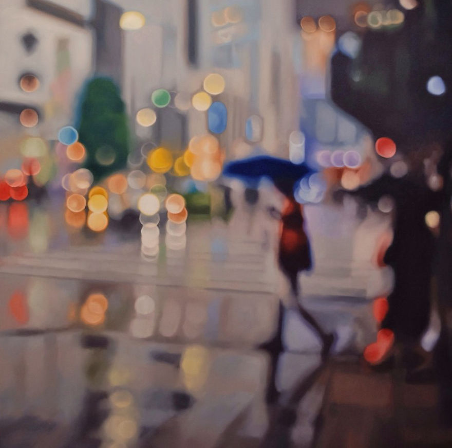 obraz sprawiający wrażenie nieostrego zdjęcia przedstawiający kobietę z parasolką w deszczu w mieście