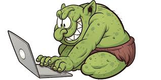 ilustracja przedstawiajaca zieonego usmiechnietego trolla przy laptopie