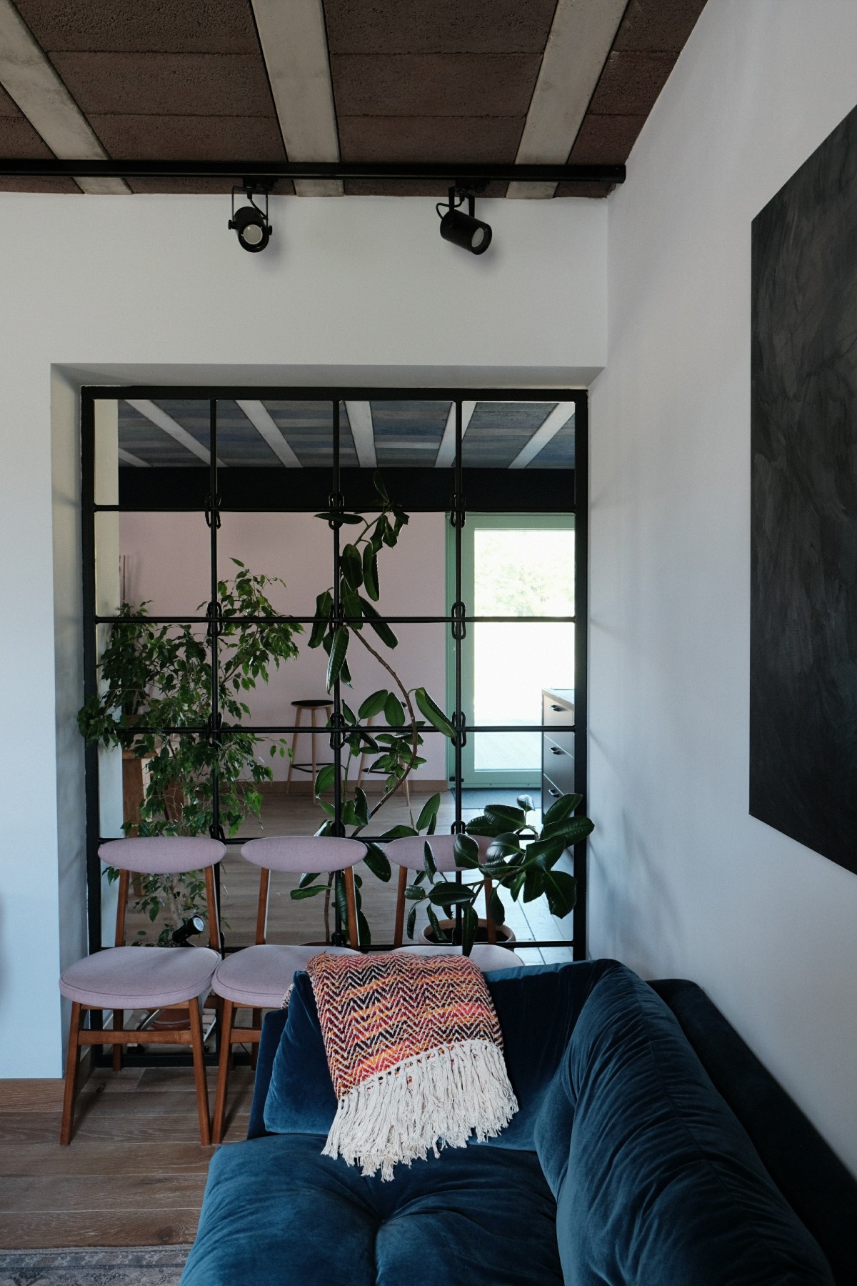 Wnętrze domu z granatową kanapą i roślinami