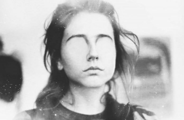Czarno-białe zdjęcie dziewczyny, która ma wymazane oczy