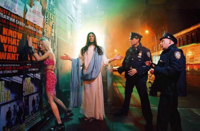 Mężczyzna przebrany za Chrystusa w towarzystwie dwóch policjantów i kobiety opartej o ścianę