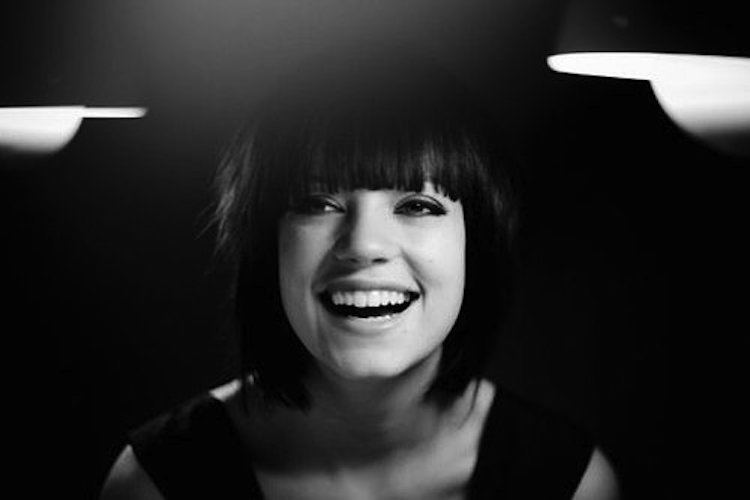 Uśmiechnięta wokalistka, czarno-białe zdjęcie.