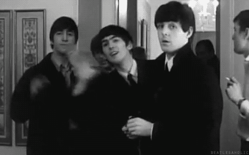 The Beatles machają, ubrani w płaszcze, czarno-białe