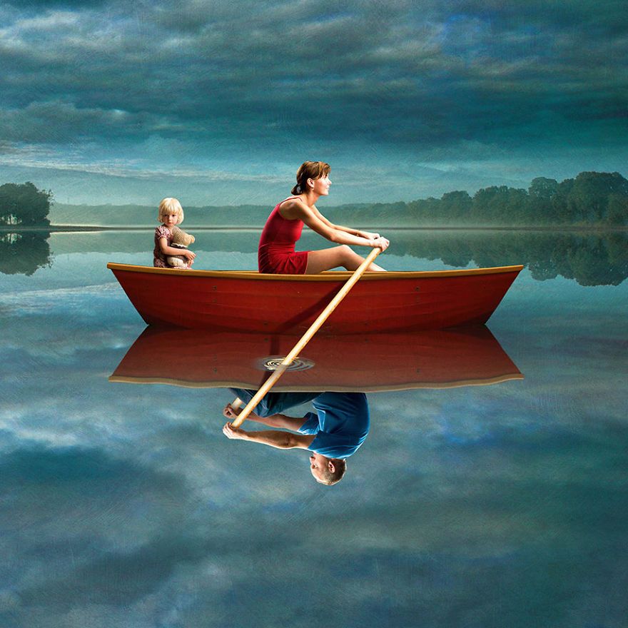surrealistyczna grafika Igora Morskiego, matka w czerwonej sukience siedzi w czerwonej łódce z córeczką przytulającą misia, w odbiciu wody w łódce siedzi ojciec w niebieskiej koszulce, oboje chcą wiosłować