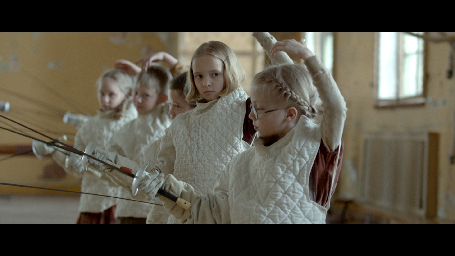 film Szermierz, dzieci ćwiczące szermierkę, dwie młode dziewczynki