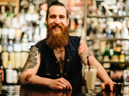 Barman z brodą i tatuażami