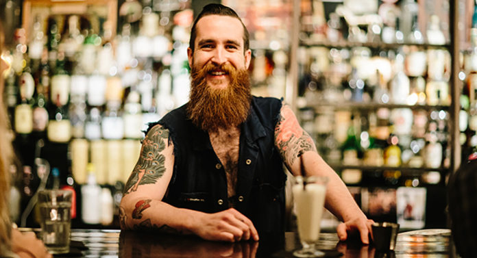 Barman z brodą i tatuażami