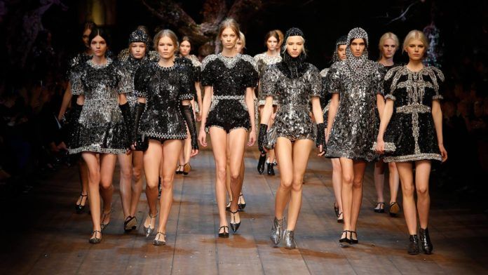 Grupa modelek w czarnych i cekinowych sukienkach na wybiegu