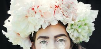 Dziewczyna w białym makijażu z wieńcem z kwiatów