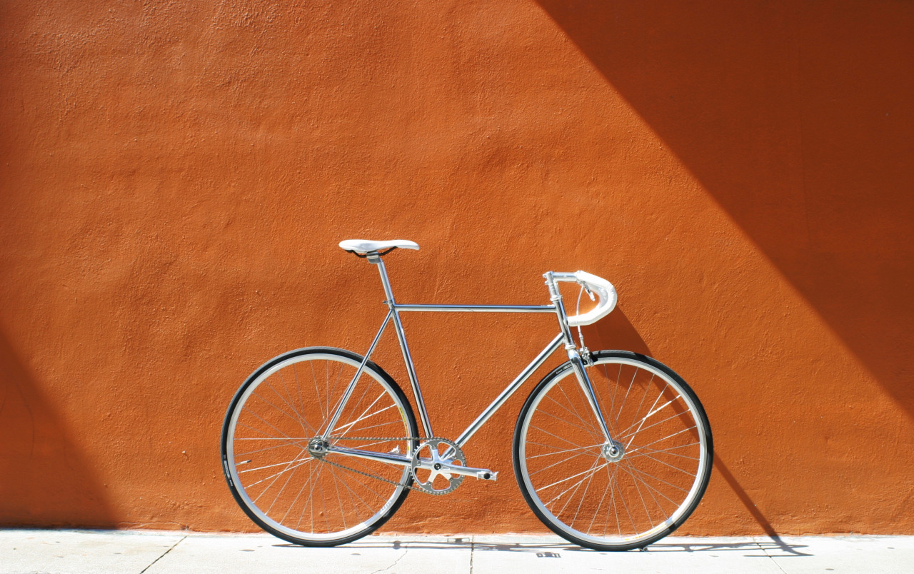 Srebrny rower na tle ceglanej ściany