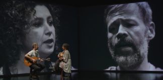 Kobieta i mężczyzna na scenie z instrumentami, w tle ich czarno-białe twarze
