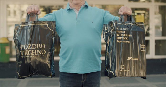 Starszy mężczyzna trzymający w rękach siatki reklamowe promujące festiwal Up To Date