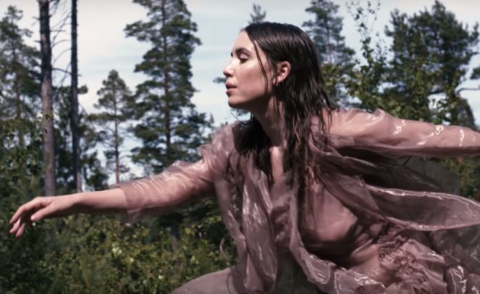 Kobieta w mokrych włosach biegnąca przez las