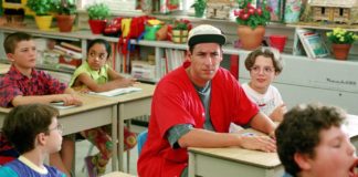 Chłopak w czerwonej koszulce siedzi w szkolnej ławce