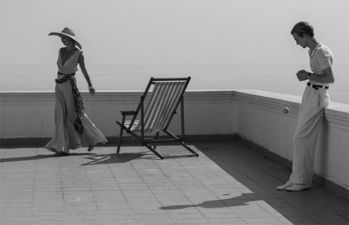 Mężczyzna i kobieta na balkonie, obok leżak