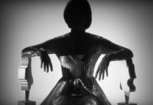 Metaliczno-czarna sylwetka siedzącej kobiety