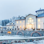 Zabytkowy pałac w trakcie zimy, opruszony śniegiem