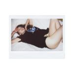 Polaroid z dziewczyną leżącą na kanapie w majtkach w ciemnej koszulce