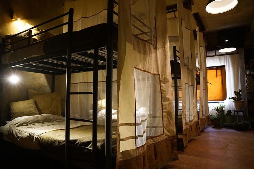 Sypialnia przypominajaca wojskowe lozka w hotelu banksyego