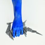Niebieska dłoń trzymająca smoka z origami
