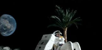 Mężczyzna na księżycu, siedzi na leżaku, obok palma