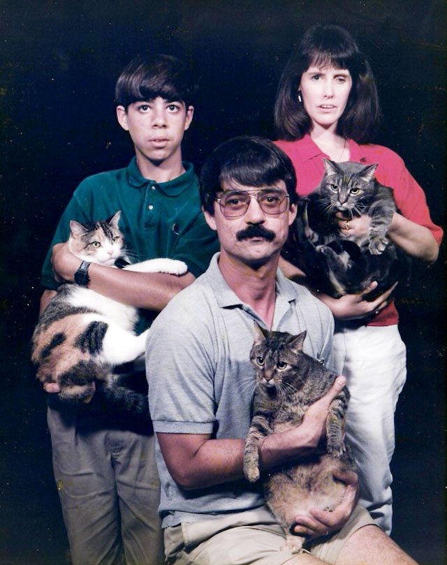 Mężczyzna z wąsem i w okularach, chłopiec z grzywką i kobieta, każdy z nich trzyma na rękach kota