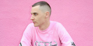 Mężczyzna ubrany na różowo na tle różowej ściany