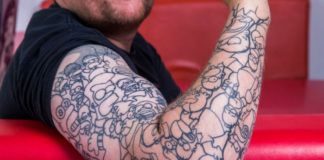 Zdjęcie przedstawia rękę mężczyzny, którą zdobi tatuaż-rękaw w motywy z serialu The Simpsons