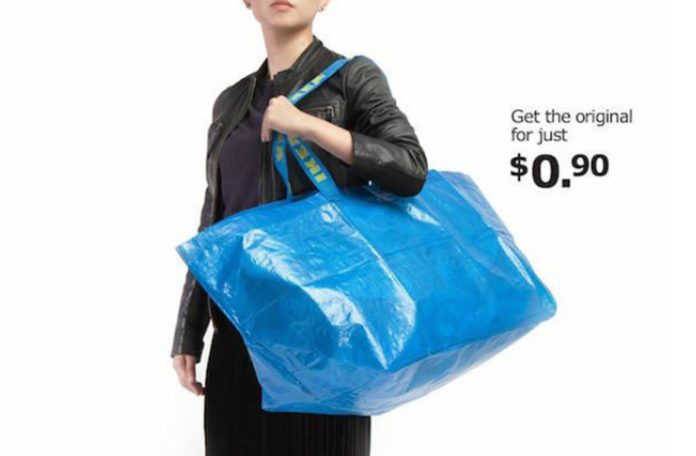 Fotografia reklamowa kolorowa. Przestawia kobietę w czerni trzymającą dużą, niebieską torbę. Na uchwytach torby widać żółte napisy IKEA. Po prawej stronie u góry czarne napisy 