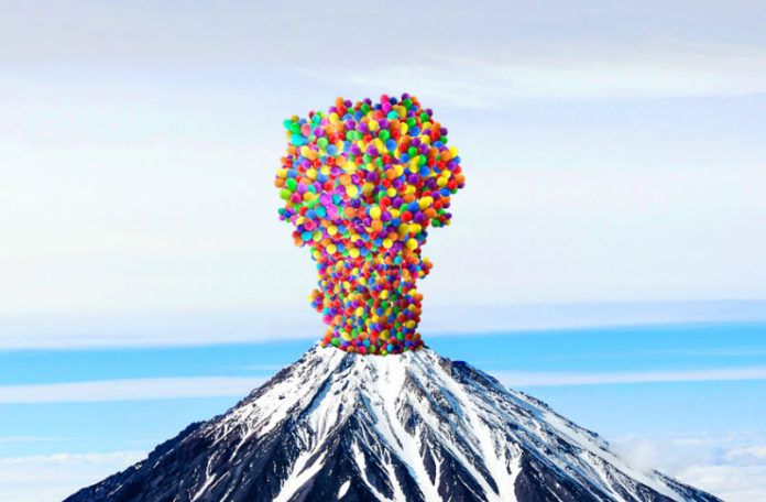 obrazek przedstawia wulkan wyrzucający ze swojego wnętrza kolorowe piłki