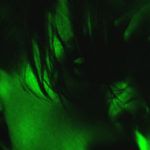 Zdjęcie z zielonym światłem z przybliżeniem na twarz mężczyzny z grzywką na czole