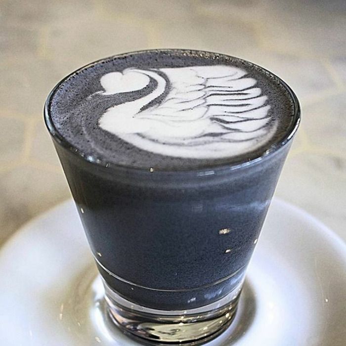 Na zdjęciu jest filiżanka z latte koloru ciemnego, zaś pianka z mleka jest w kształcie łabędzia.