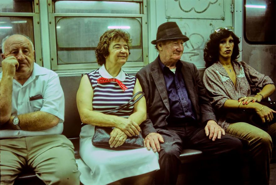 zdjęcie przedstawia dwie kobiety i dwóch mężczyzn siedzących wewnątrz wagonu pociągu