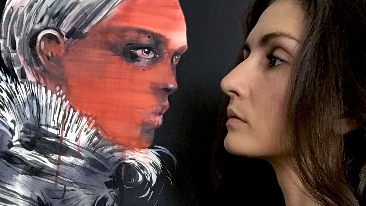 Twarz pieknej kobiety profilem brunetki na tle obrazu przedstawiajacego czerwona twarz skierowana w strone kobiety obie patrza na siebie pieknymi oczyma oczy namalowanej postaci sa szkliste cala postac namalowana jest na czarnym tle