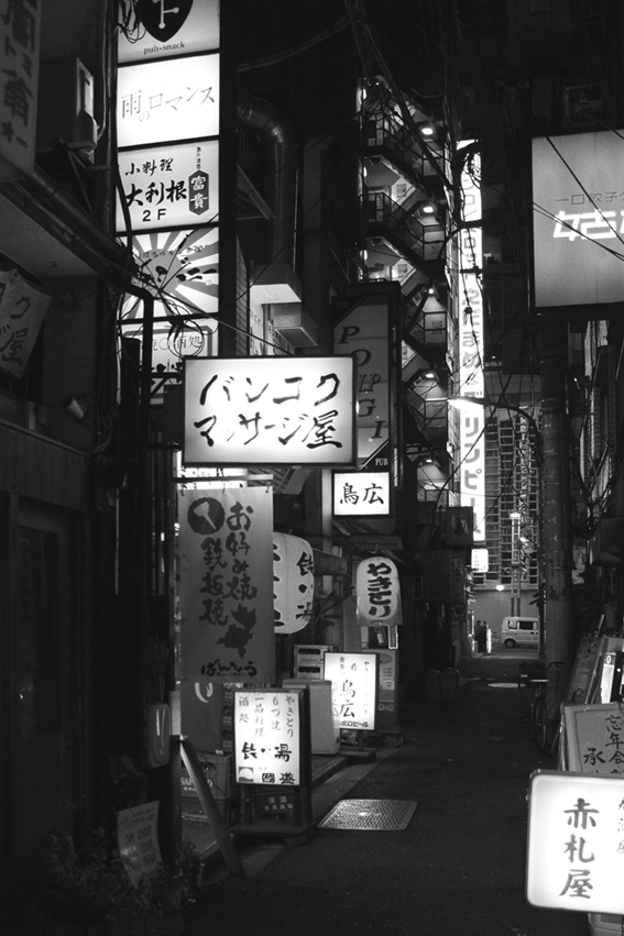 Gif przedstawia ulicę w Tokio pełną neonów, a po chwili jest ona ciemna bez neonów.
