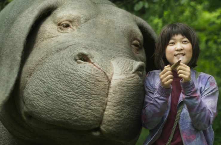Azjatycka dziewczynka, a obok niej duża, zmutowana świnia