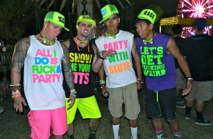 Czterech meżczyzn na festiwalu muzycznym - ubrani w koszulki z obscenicznymi napisami.