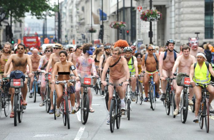 Zdjęcie przedstawia tłum nudystów na rowerach