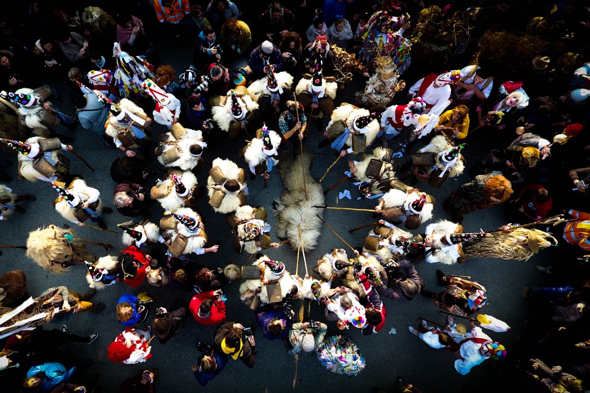 Zdjecie ludzi z perspektywy lotu ptaka, ktorzy biorą udział w hiszpańskim festiwalu La vijanera. . Przedstawia grupę uczestników, ktorzy stoją nad owczą skrórą.