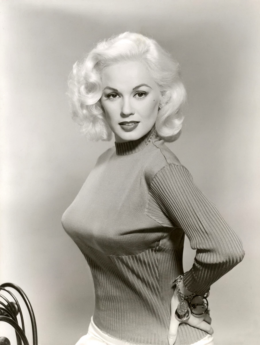 Czarno-białe zdjęcie przedstawiające blondynkę w swetrze