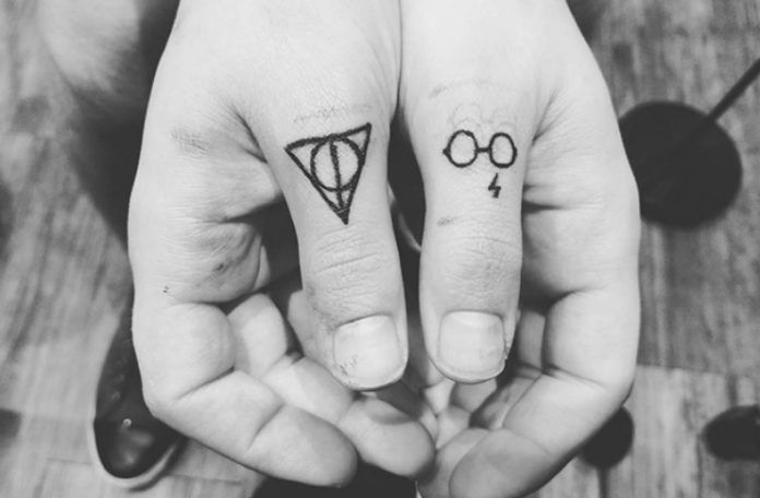 Tatuaże na kciukach z Insygniami Śmierci i okularami Harry'ego