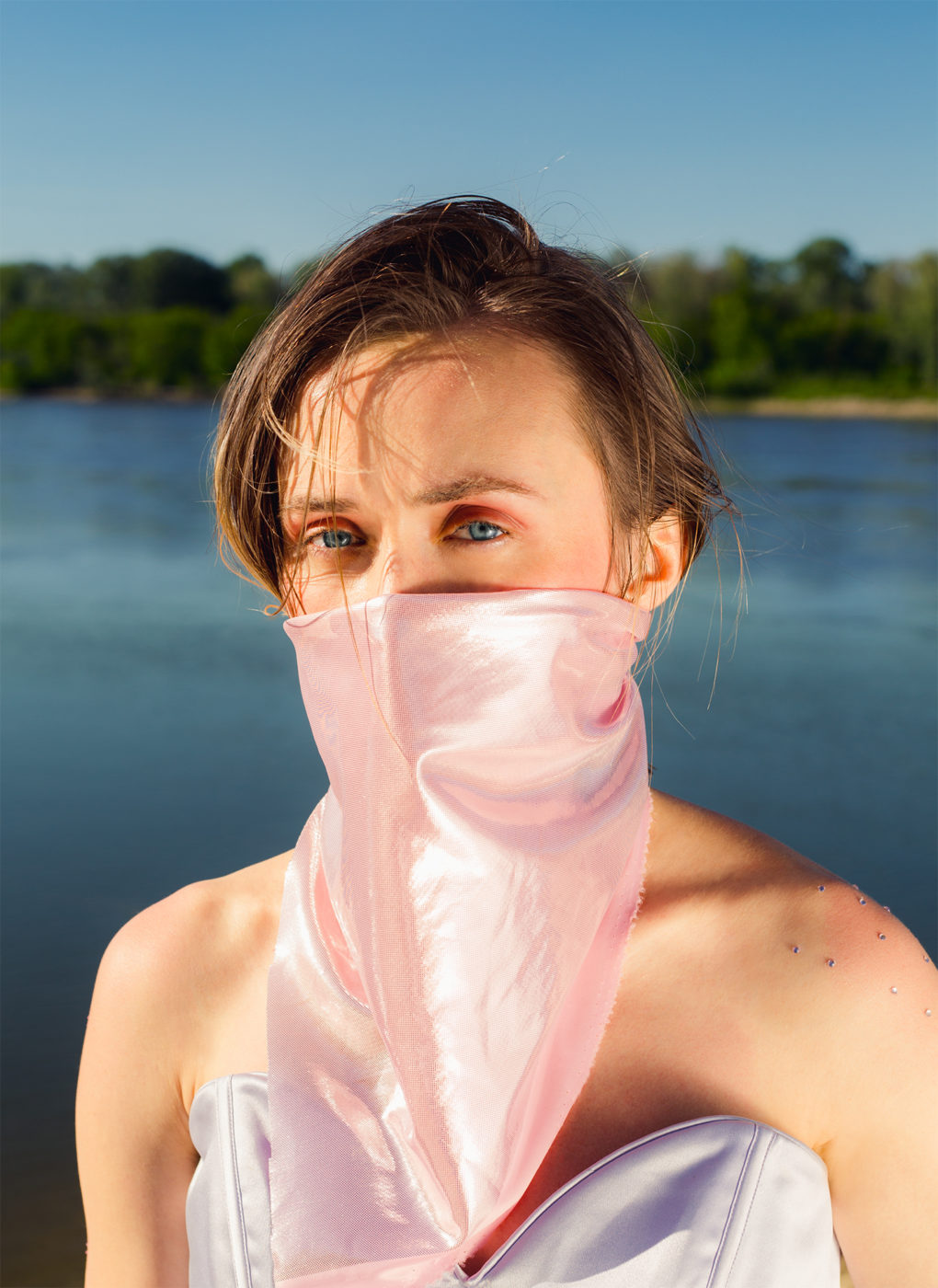 Dziewczyna z różową bandaną na twarzy, zakrywającą nos i usta